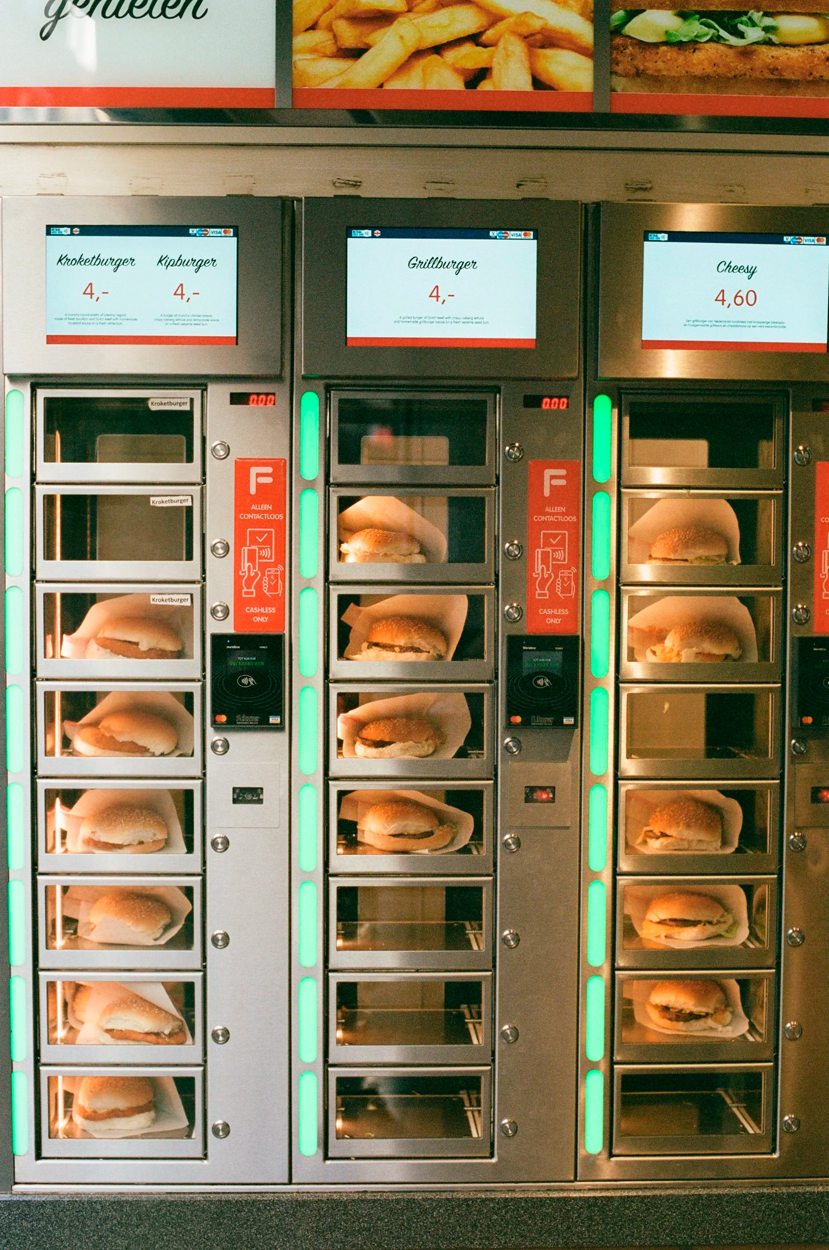 Rows of warm burgers in a vending machine, with prices and payment options.